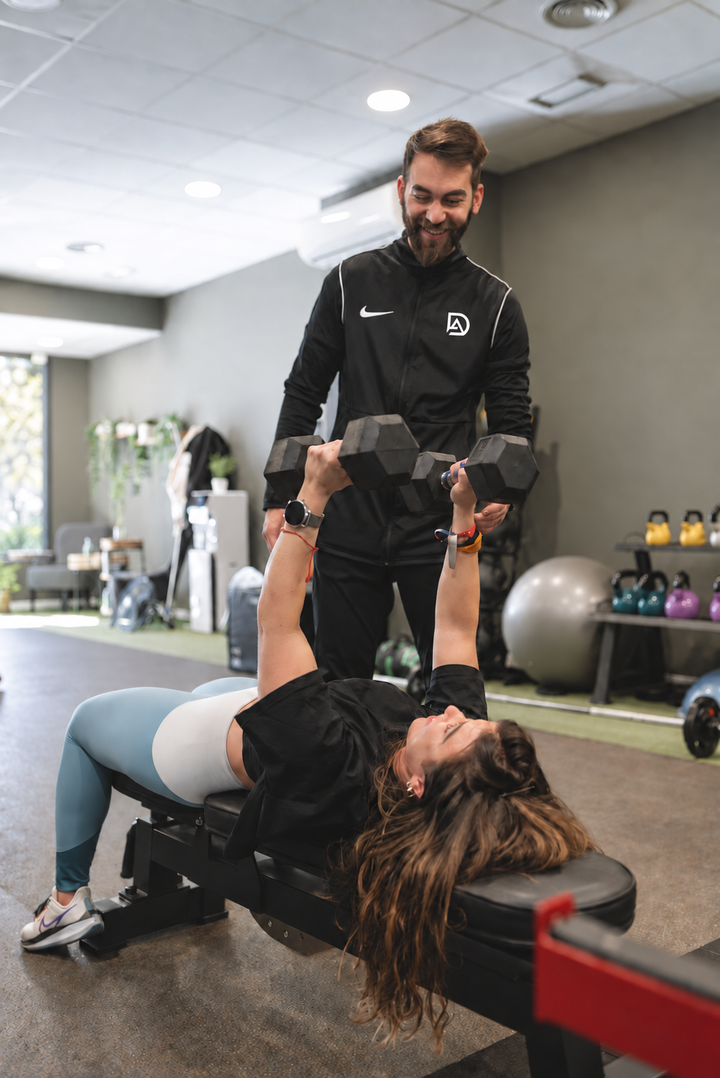 David asistiendo a una deportista durante un ejercicio de fuerza