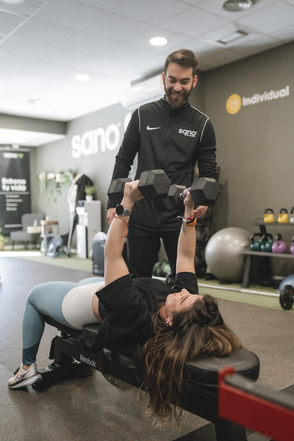 David asistiendo a una deportista durante un ejercicio de fuerza