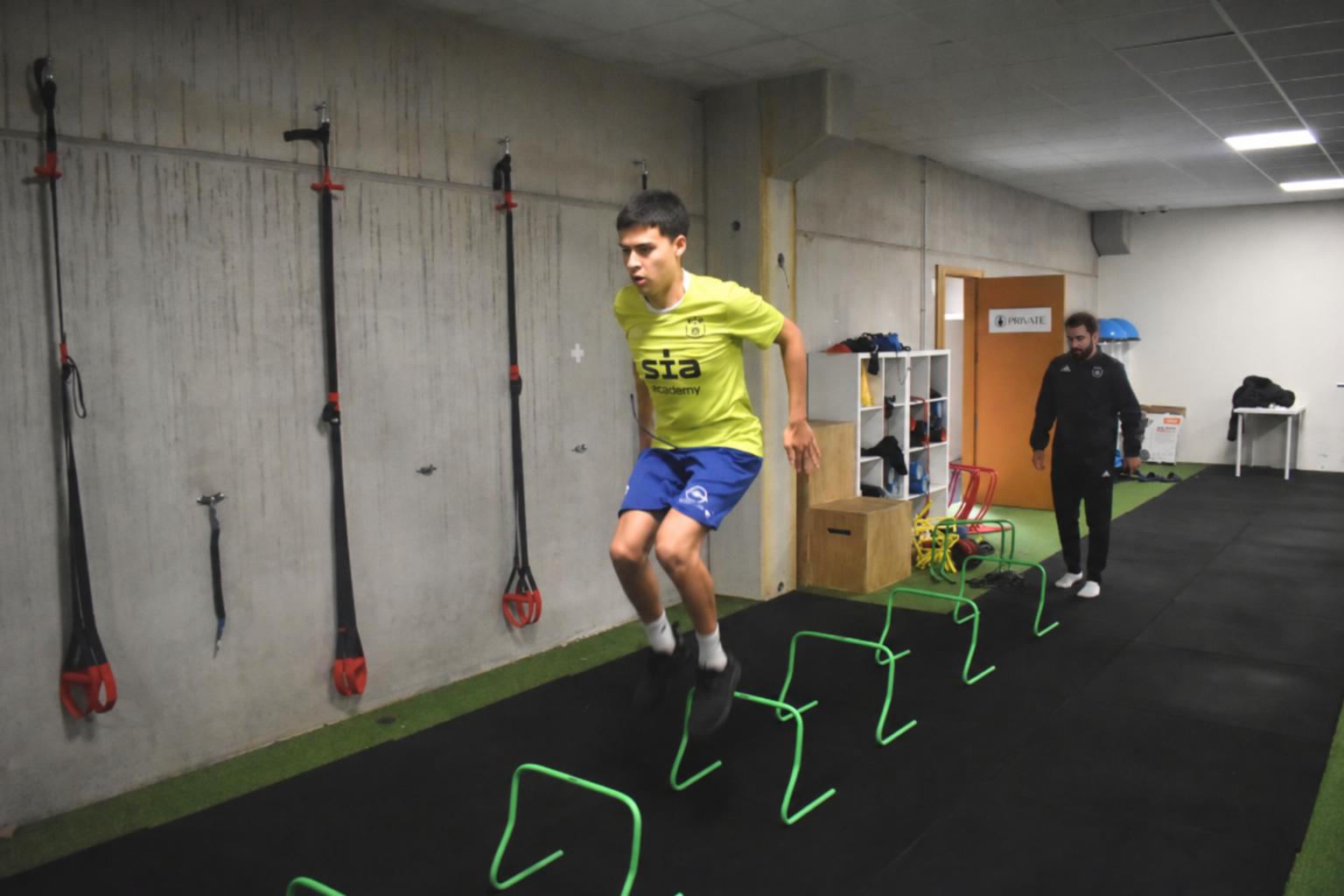 David Adanero supervisando a un futbolista durante un trabajo específico de saltos sobre vallas