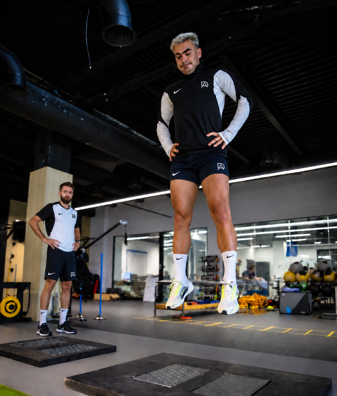 David Adanero supervisando a un futbolista con equipación negra y blanca durante un ejercicio específico de salto y potencia