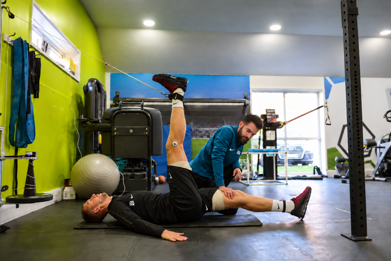 David Adanero asistiendo a un futbolista durante un trabajo específico de movilidad y fuerza