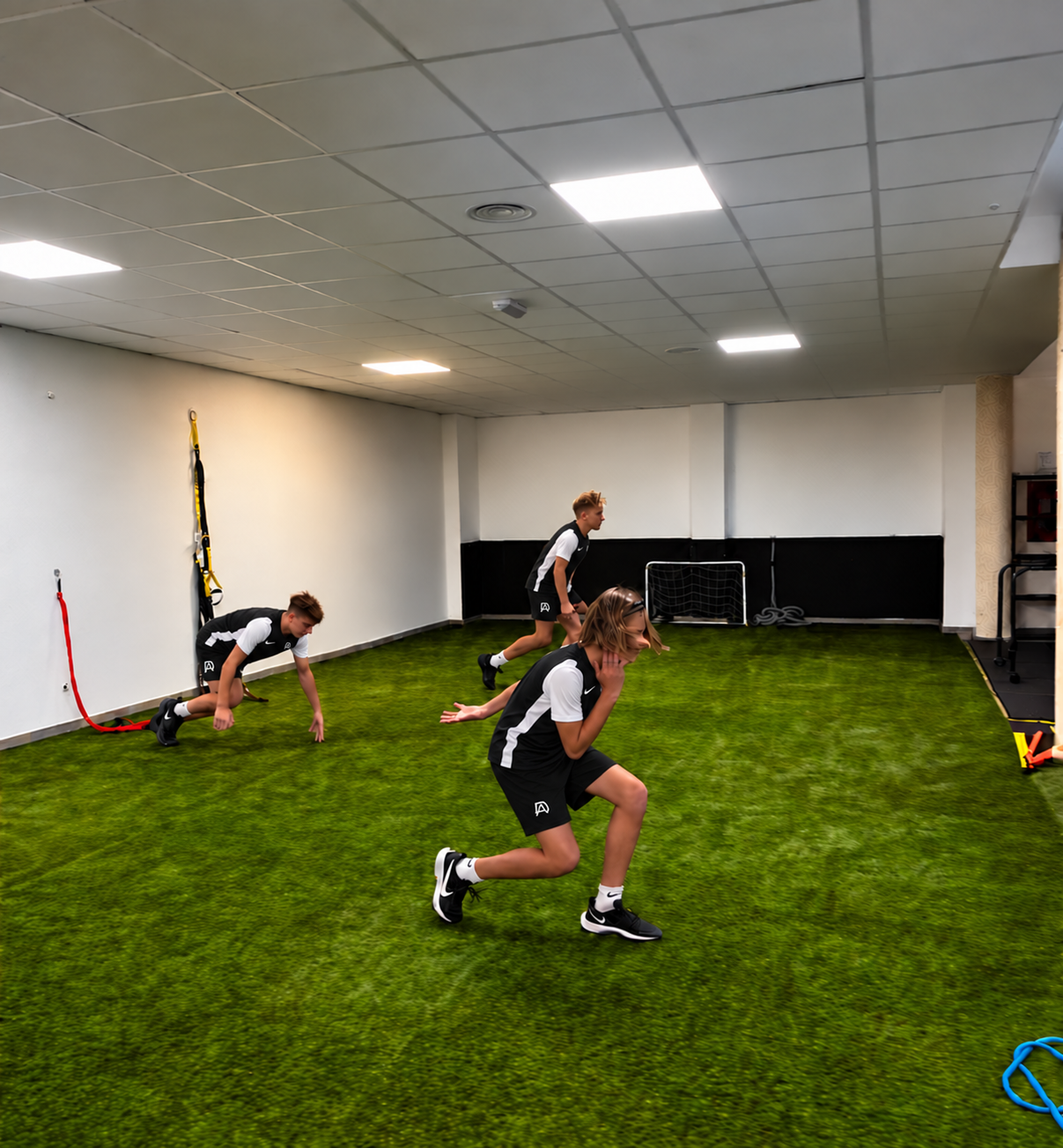Futbolistas con equipación negra y blanca realizando un trabajo específico de velocidad y aceleración